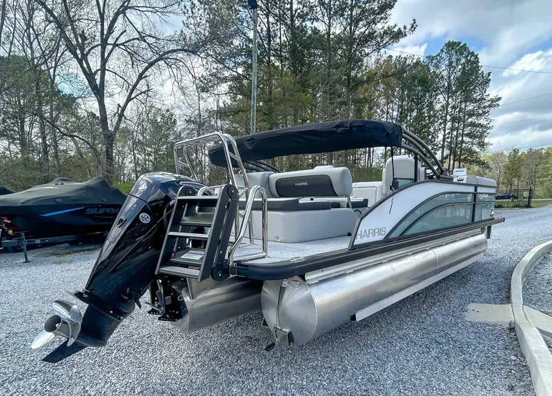 Slide: The Image of 2025 Harris CRUISER 230 SLDH pontoon boat with sleek design, parked on gravel. - 7