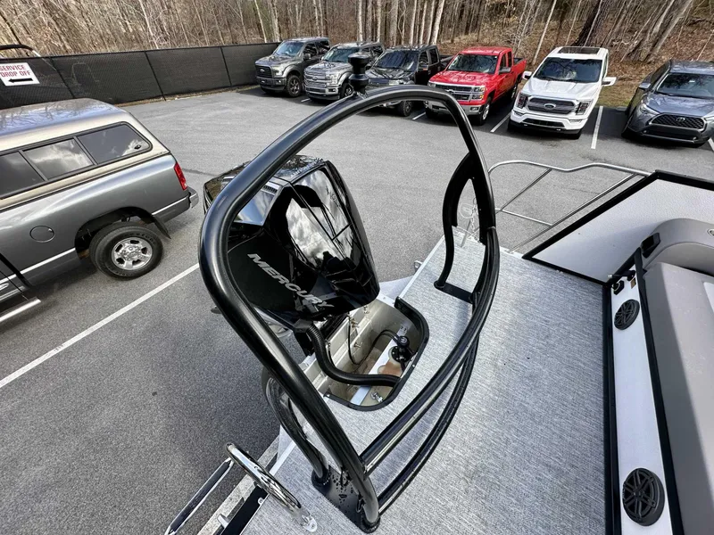 Slide: The Image of 2024 Premier 250 Solaris RL boat with Mercury engine, parked near trucks and cars. - 13