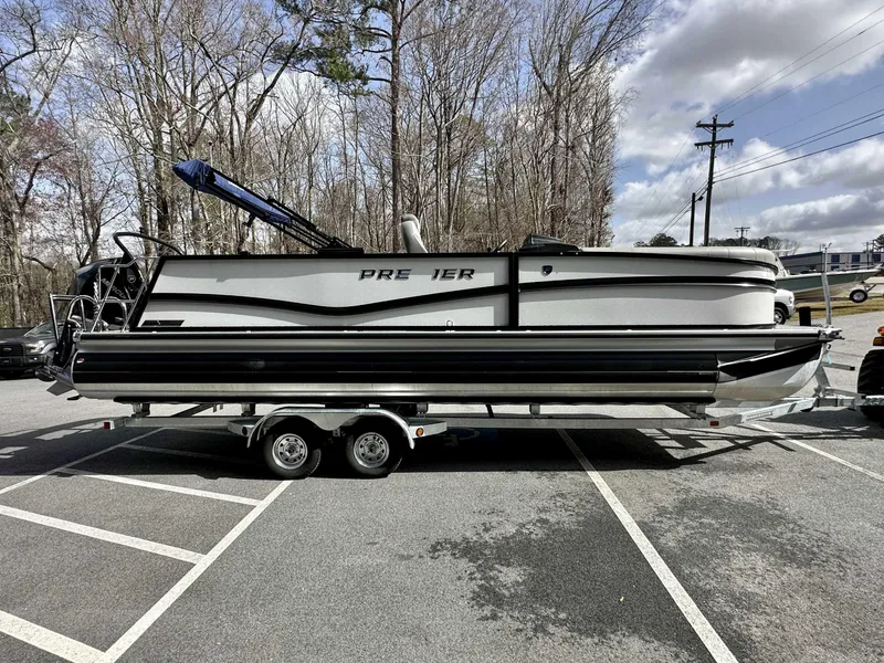 Slide: The Image of 2024 Premier 250 Solaris RL pontoon boat on trailer in parking lot. - 5