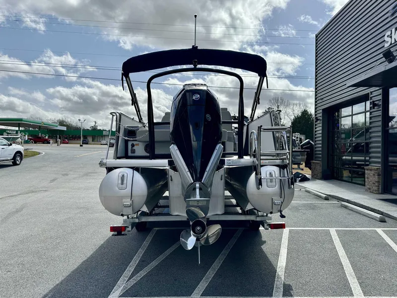 Slide: The Image of 2024 Premier 250 Solaris RL pontoon boat parked outside a showroom on a cloudy day. - 7