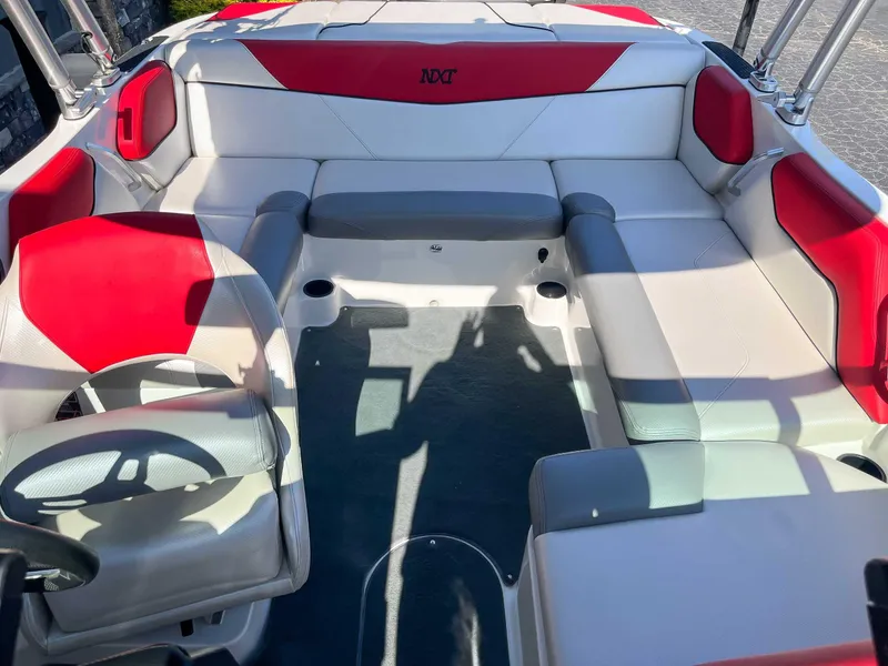 Slide: The Image of 2015 MasterCraft NXT20 interior with red and white seating, spacious layout. - 11