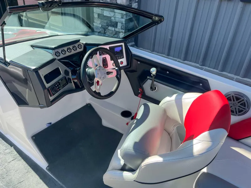 Slide: The Image of 2015 MasterCraft NXT20 boat interior with steering wheel, dashboard, and red-accented seat. - 13