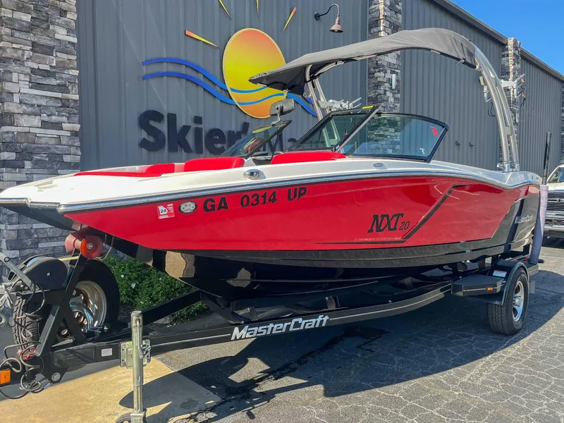 Slide: The Image of 2015 MasterCraft NXT20 boat in red, parked on a trailer outside a building. - 3