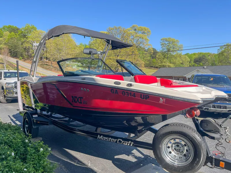 Slide: The Image of 2015 MasterCraft NXT20 boat with red and white design on a trailer. - 5