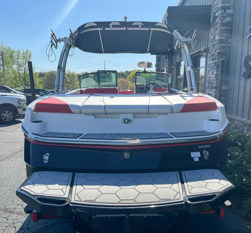 Slide: The Image of 2015 MasterCraft NXT20 boat, rear view, parked outdoors, showcasing swim platform and tower. - 7