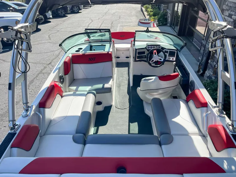 Slide: The Image of 2015 MasterCraft NXT20 boat interior with red and white seating, steering wheel, and dashboard. - 9