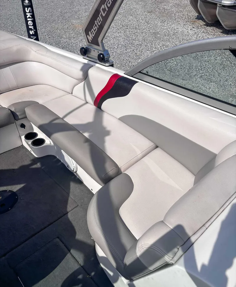 Slide: The Image of 2008 MasterCraft X1 boat interior with gray and white seating, cup holders, and branding. - 15