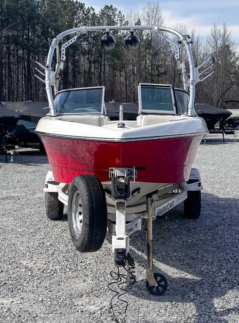 Slide: The Image of 2008 MasterCraft X1 boat on trailer, red hull, parked on gravel lot. - 4