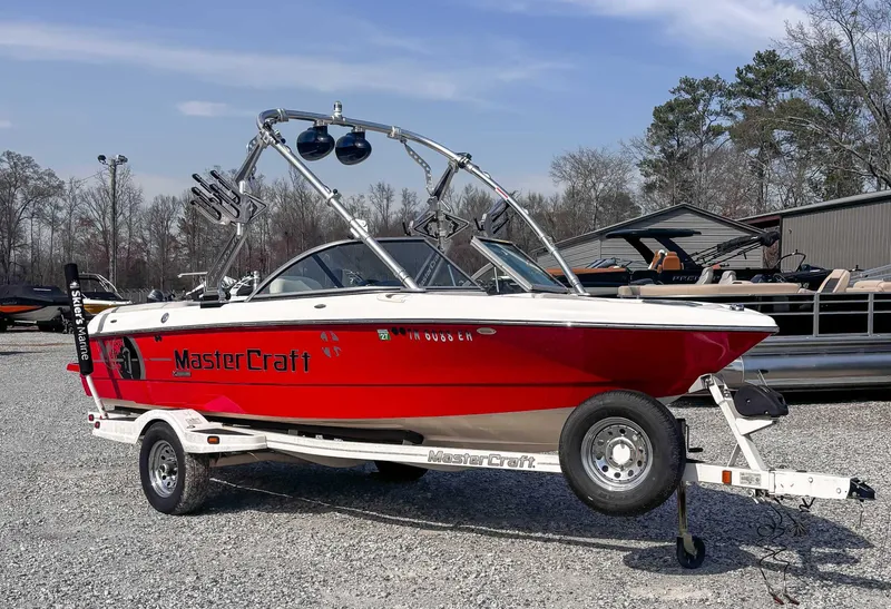 Slide: The Image of 2008 MasterCraft X1 boat on trailer, red and white, parked outdoors. - 5