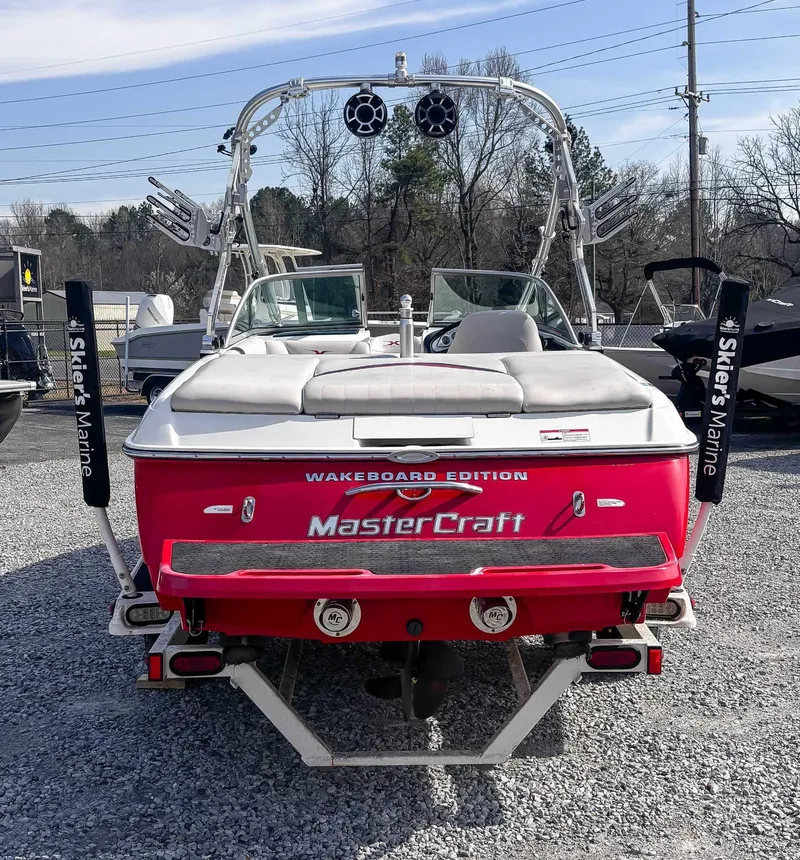 Slide: The Image of 2008 MasterCraft X1 wakeboard boat, red, rear view, parked on gravel lot. - 9