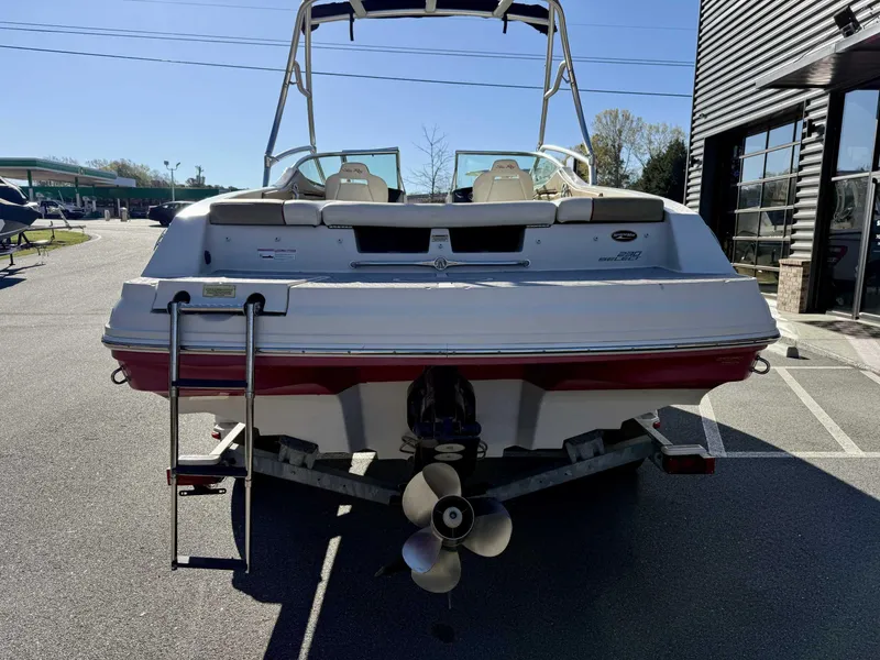 Slide: The Image of 2007 Sea Ray 230 Select boat, rear view with ladder and propeller, parked outdoors. - 8