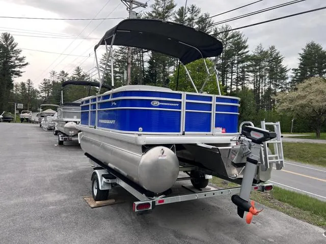 Slide: The Image of 2023 Princecraft Brio E 170 pontoon boat on trailer, blue exterior, parked outdoors. - 2