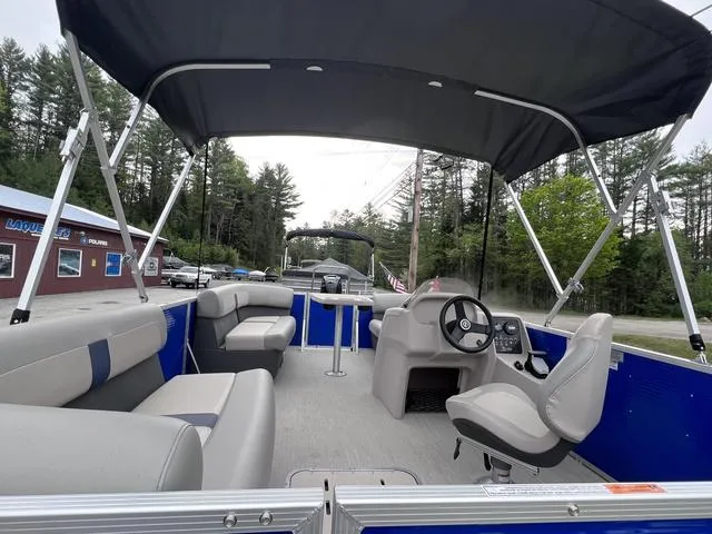Slide: The Image of 2023 Princecraft Brio E 170 pontoon boat with canopy, spacious seating, and modern controls. - 4