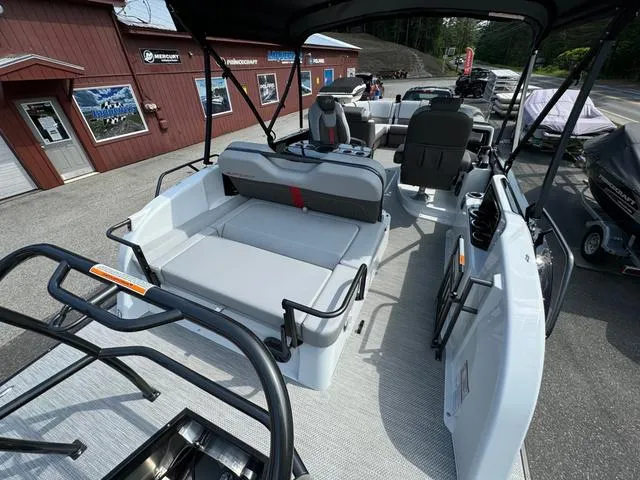 Slide: The Image of 2024 Princecraft Vogue® 23 RL pontoon boat interior with seating and helm, displayed outdoors. - 18