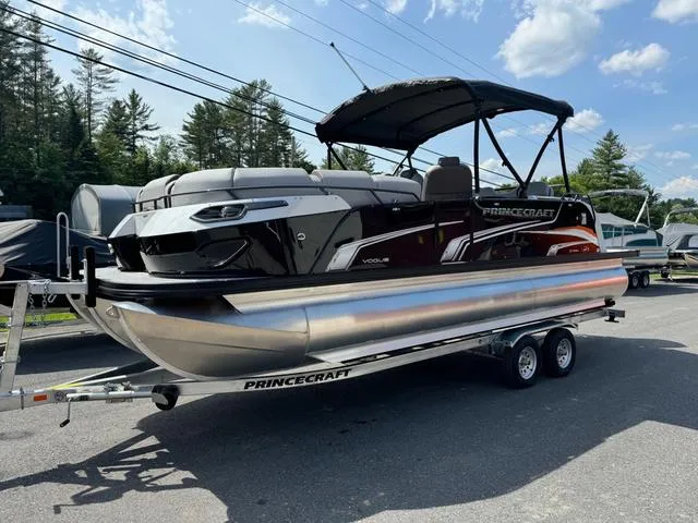 Slide: The Image of 2024 Princecraft Vogue® 23 RL pontoon boat on trailer, parked outdoors. - 2