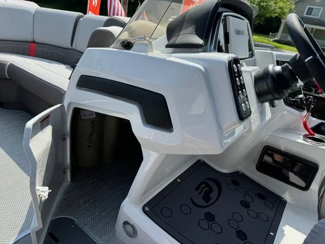 Slide: The Image of 2024 Princecraft Vogue® 23 RL boat interior with steering console and seating area. - 23