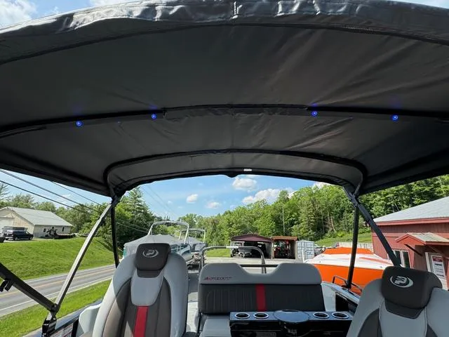 Slide: The Image of 2024 Princecraft Vogue® 23 RL boat interior with canopy and seating, scenic outdoor view. - 33