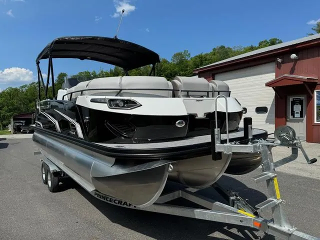Slide: The Image of 2024 Princecraft Vogue® 23 RL pontoon boat on trailer, parked near a building. - 4
