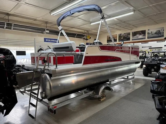 Slide: The Image of 2025 Princecraft Vectra 21 RL 115HP pontoon boat in showroom, featuring red and white design. - 3