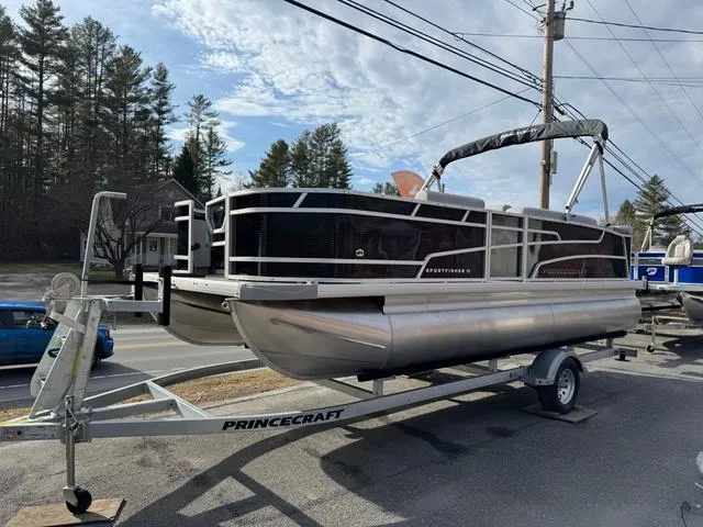 Slide: The Image of 2025 Princecraft SportFisher 21-2S 90HP pontoon boat on trailer, parked outdoors. - 1