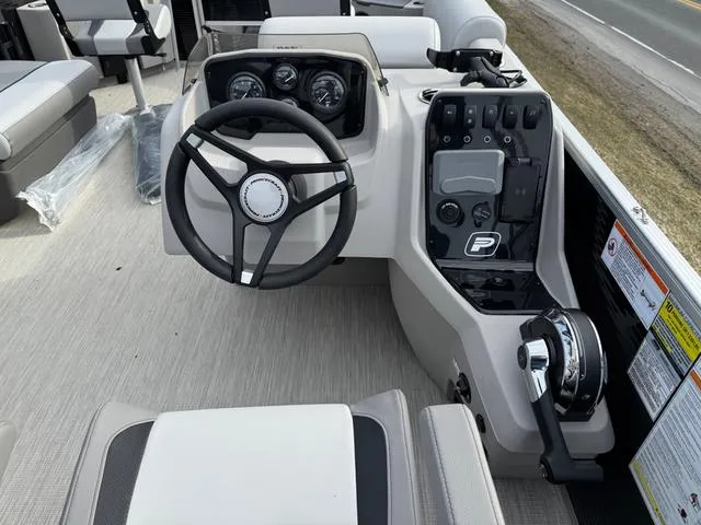 Slide: The Image of 2025 Princecraft SportFisher 21-2S 90HP boat dashboard with steering wheel and controls. - 12
