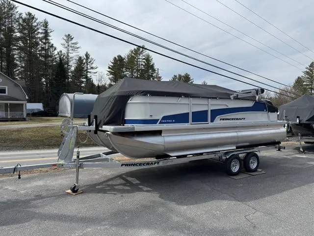Slide: The Image of 2025 Princecraft Vectra 21 RL 150HP pontoon boat on trailer, covered, parked outdoors. - 1