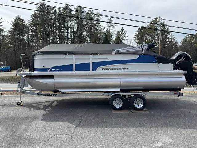 Slide: The Image of 2025 Princecraft Vectra 21 RL 150HP pontoon boat on trailer, parked outdoors. - 2