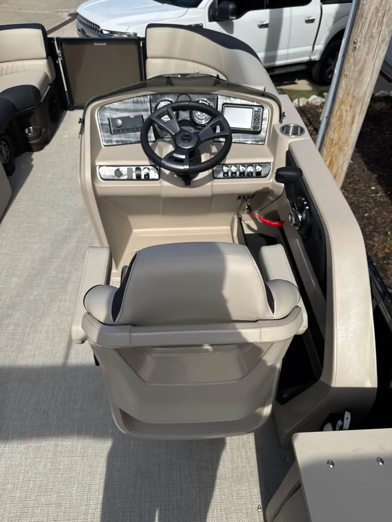 Slide: The Image of 2025 Tahoe Pontoon LTZ Cruise Rear Bench helm with modern controls and beige seating. - 7