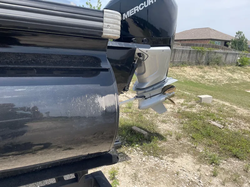 Slide: The Image of 2023 Regency 250 DL3 boat with Mercury outboard motor, parked on grassy area. - 11