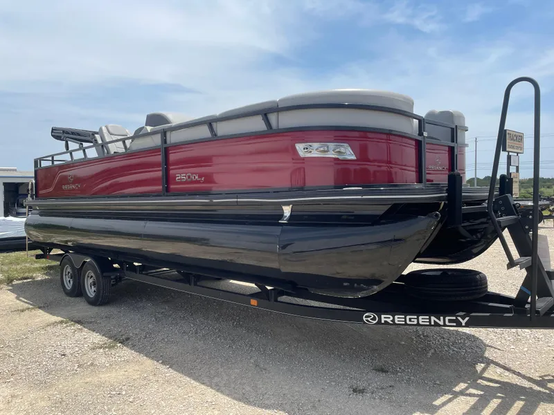 Slide: The Image of 2023 Regency 250 DL3 pontoon boat on trailer, red and black design, parked outdoors. - 7