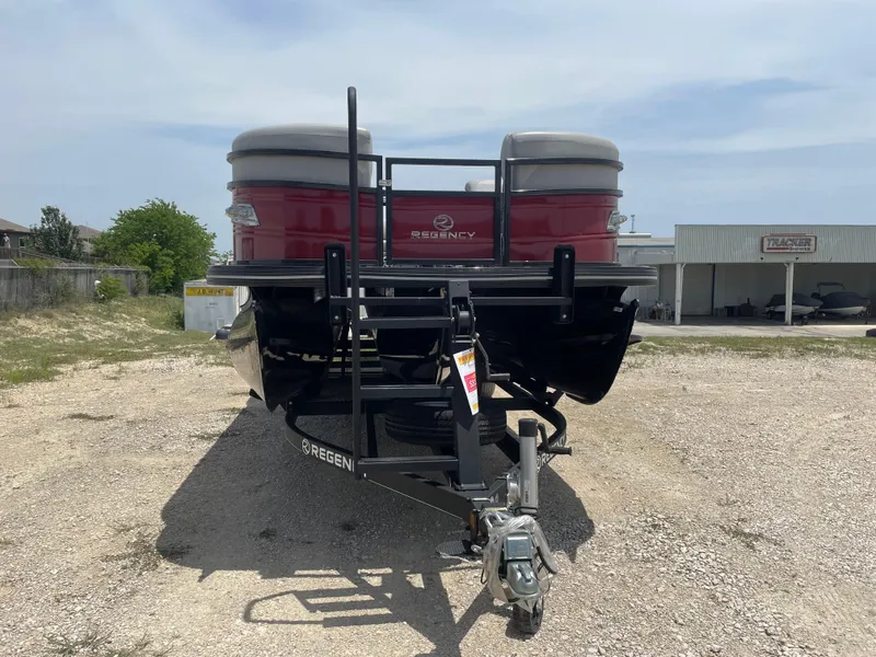 Slide: The Image of 2023 Regency 250 DL3 pontoon boat on a trailer, parked outdoors. - 8