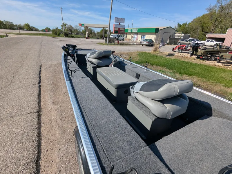 Slide: The Image of 2017 Tracker Panfish 16 boat with gray seating, parked on a roadside. - 13
