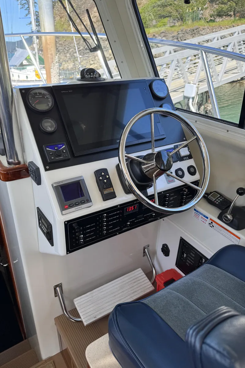 Slide: The Image of 2010 Ocean Sport Roamer boat dashboard with steering wheel and navigation controls. - 12