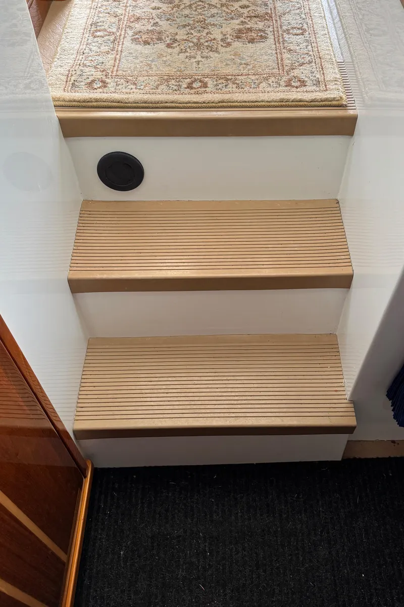 Slide: The Image of Wooden steps with carpet runner on a 2010 Ocean Sport Roamer boat. - 31