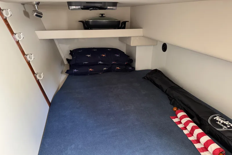 Slide: The Image of 2010 Ocean Sport Roamer cabin interior with bed, pillows, and storage space. - 35