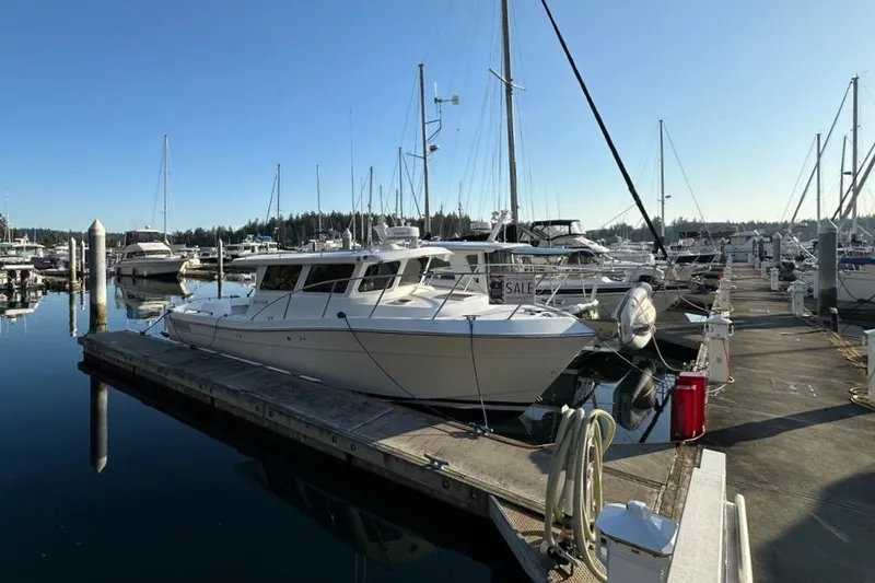 Slide: The Image of Ocean Sport Roamer 2010 docked at marina, surrounded by other boats under clear blue sky. - 47
