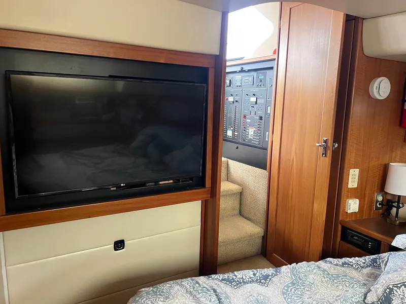 Slide: The Image of 1999 Bayliner 4087 Aft Cabin Motoryacht interior with TV, stairs, and control panel. - 18