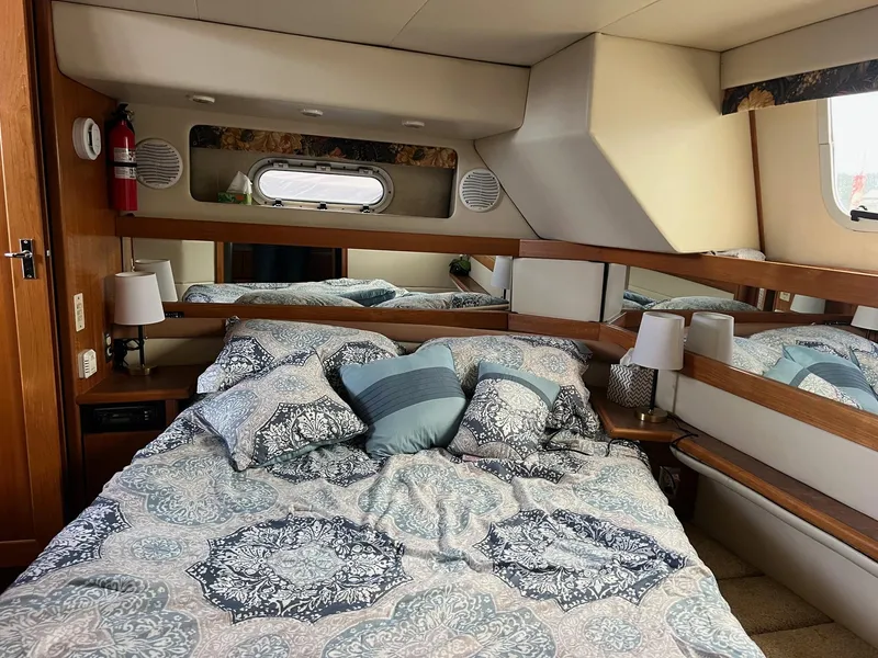 Slide: The Image of 1999 Bayliner 4087 Aft Cabin Motoryacht bedroom with patterned bedding and wooden accents. - 20