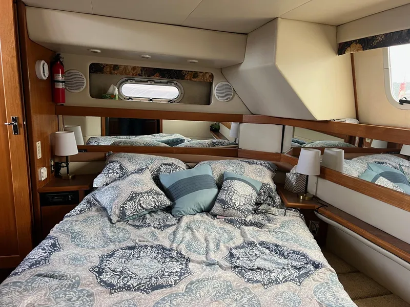 Slide: The Image of 1999 Bayliner 4087 Aft Cabin Motoryacht bedroom with patterned bedding and wooden accents. - 21
