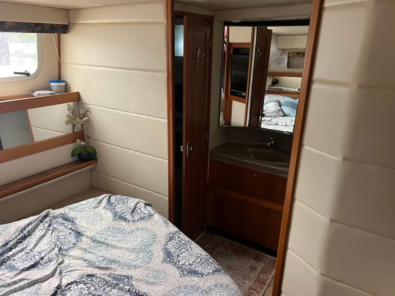 Slide: The Image of 1999 Bayliner 4087 Aft Cabin Motoryacht interior with bed, sink, and mirror. - 22