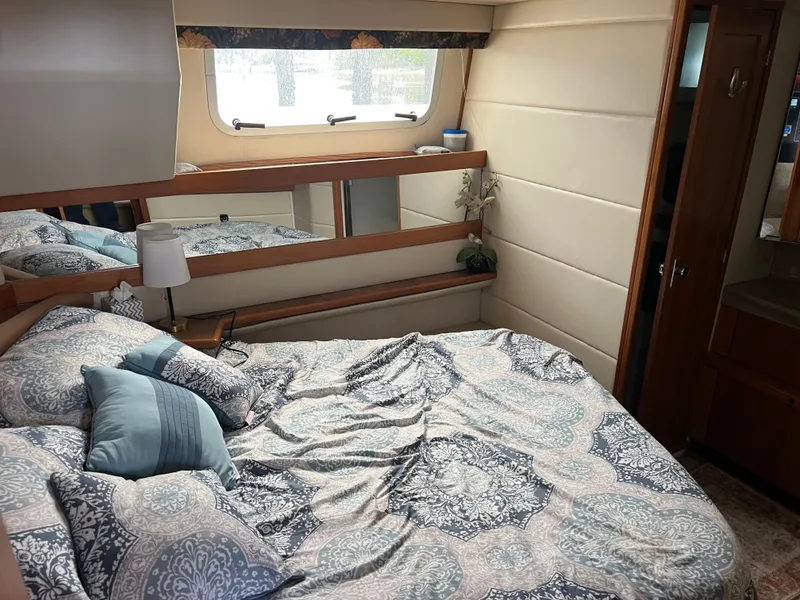 Slide: The Image of 1999 Bayliner 4087 Aft Cabin Motoryacht bedroom with cozy bed and elegant decor. - 23