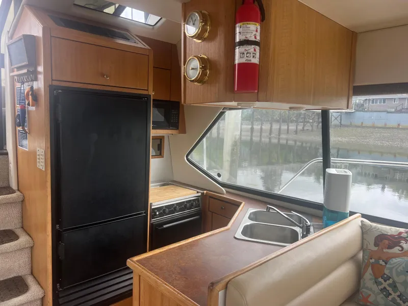 Slide: The Image of 1999 Bayliner 4087 Aft Cabin Motoryacht interior with kitchen, sink, and large window view. - 33