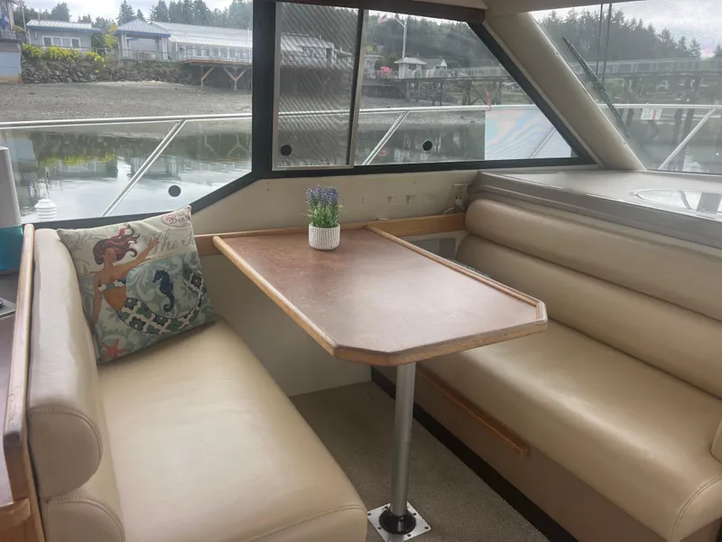 Slide: The Image of 1999 Bayliner 4087 Aft Cabin Motoryacht interior with dining area and scenic window view. - 34