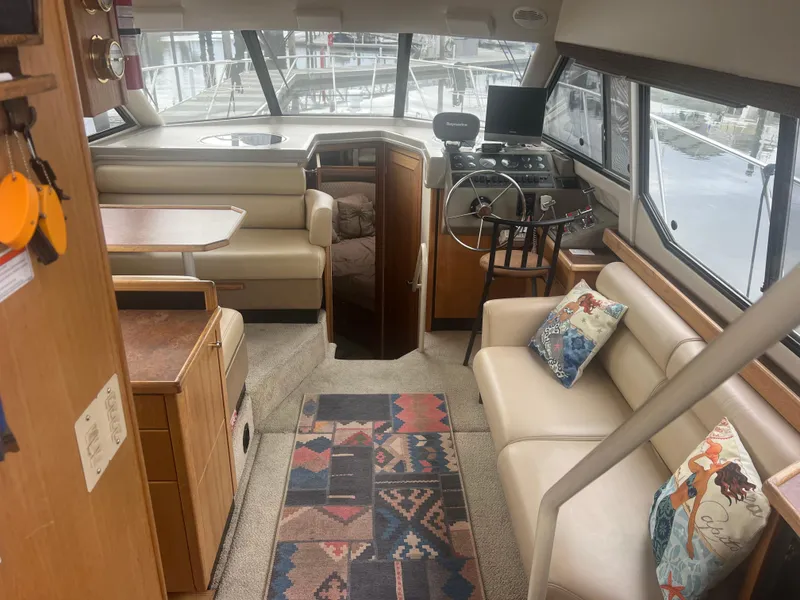 Slide: The Image of 1999 Bayliner 4087 Aft Cabin Motoryacht interior with seating, helm, and decorative rug. - 36