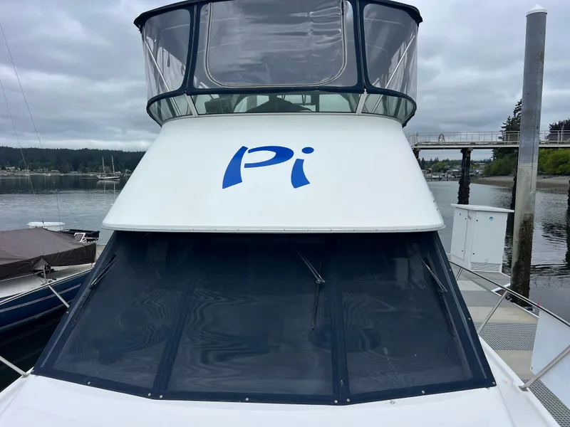 Slide: The Image of 1999 Bayliner 4087 Aft Cabin Motoryacht docked, featuring "Pi" on the cabin. - 4