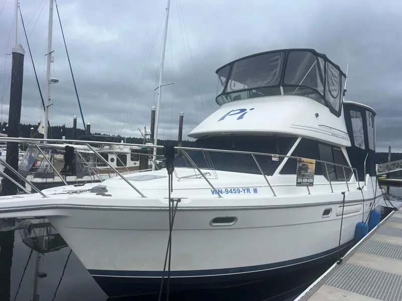 Slide: The Image of 1999 Bayliner 4087 Aft Cabin Motoryacht docked at marina, featuring enclosed upper deck. - 42