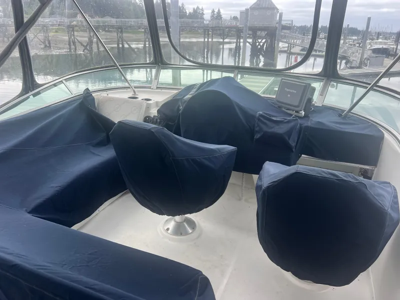 Slide: The Image of 1999 Bayliner 4087 Aft Cabin Motoryacht helm with covered seats and navigation equipment. - 6