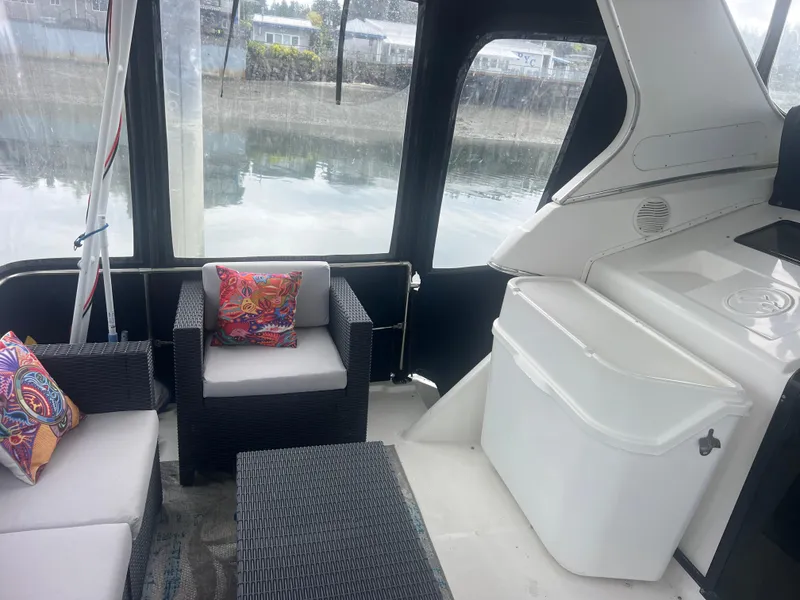 Slide: The Image of 1999 Bayliner 4087 Aft Cabin Motoryacht interior with wicker seating and colorful cushions. - 7