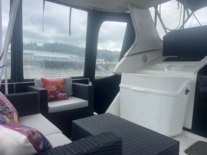 Slide: The Image of 1999 Bayliner 4087 Aft Cabin Motoryacht interior with wicker seating and colorful cushions. - 8