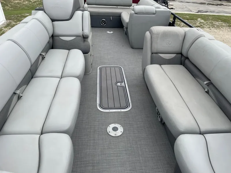 Slide: The Image of 2022 Regency 250 DL3 pontoon boat interior with gray seating and flooring. - 12